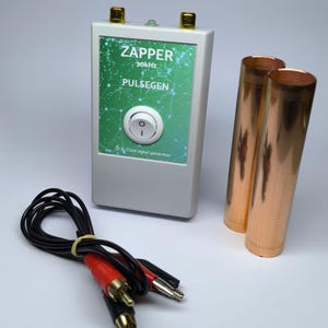 May include: A white rectangular Zapper Pulsegen signal generator with a green label featuring the text ZAPPER 30kHz PULSEGEN Dr H. Clark signal generator, a central white power switch, two copper cylinders, and a black cable with red and black connectors.