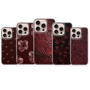 Könnte beinhalten: Fünf Handyhüllen mit verschiedenen Designs in Rot- und Burgundertönen. Die Muster umfassen Blumen, Schleifen und Reptilienhautstrukturen. Jede Hülle hat einen transparenten Rand. Die Designs sind vielfältig.