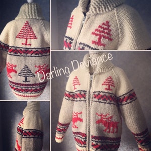 Könnte beinhalten: Ein cremefarbener Strickcardigan mit Reißverschluss. Der Cardigan hat ein rotes und schwarzes geometrisches Muster mit roten Rentieren und Tannenbaummotiven. Der Text "Darling Deviance" ist auf dem Bild zu sehen.