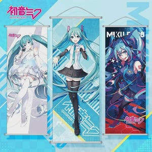May include: Three vertical wall scrolls featuring anime-style illustrations of a character with long, turquoise hair. The scrolls display the text "Hatsune Miku" in Japanese and English. Each scroll has a different pose and outfit for the character, with varying color schemes of blue, white, and black.