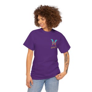 May include: A purple t-shirt with a colourful lightning bolt design and the word "SPICY" printed beneath. The t-shirt is worn by a person in blue jeans.