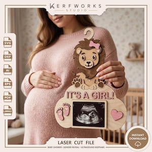 May include: A laser-cut wooden sign featuring a cartoon lion with a pink bow, the text "IT'S A GIRL!", two small pink footprints, and a heart shape. The sign includes a central rectangular frame designed to hold a baby ultrasound image.