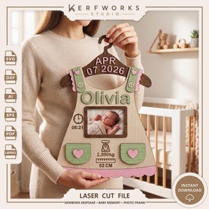 K&ouml;nnte beinhalten: Eine lasergeschnittene Baby-Erinnerungstafel aus Holz in Form eines Kleides auf einem Kleiderb&uuml;gel. Sie zeigt den Namen Olivia, das Datum APR 07 2026, einen Fotorahmen, eine Uhr mit 08:21, eine Waage mit 2,850kg und ein Lineal mit 52 CM.