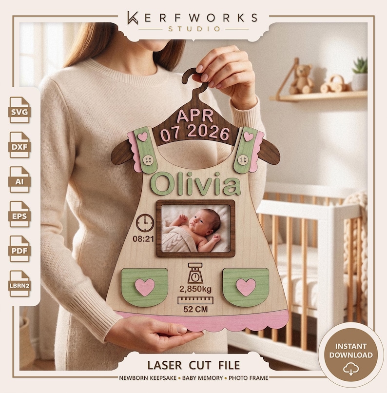 K&ouml;nnte beinhalten: Eine lasergeschnittene Baby-Erinnerungstafel aus Holz in Form eines Kleides auf einem Kleiderb&uuml;gel. Sie zeigt den Namen Olivia, das Datum APR 07 2026, einen Fotorahmen, eine Uhr mit 08:21, eine Waage mit 2,850kg und ein Lineal mit 52 CM.