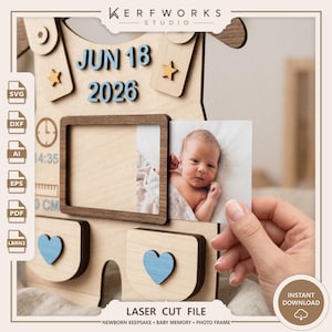 K&ouml;nnte beinhalten: Ein lasergeschnittener Baby-Erinnerungsrahmen aus Holz mit dem blauen Text JUN 18 2026, zwei kleinen Holzsternen, einem Uhrensymbol mit 14:35 Uhr, einer Linealgrafik und zwei blauen Herzakzenten. Der Rahmen enth&auml;lt ein Foto eines Neugeborenen.
