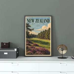May include: A framed vertical wall art print titled NEW ZEALAND GOLF CLUB SURREY. The illustration depicts a green golf course fairway lined with tall pine trees, with purple heather in the foreground under a blue sky with white clouds.