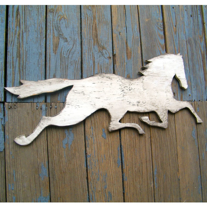 May include: White wooden silhouette of a horse running, mounted on a weathered wood background.
