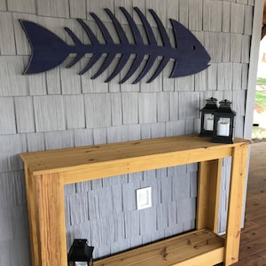 Haven America Fish Skeleton is shown outdoors in a boat house in our Atlantic Navy Blue color. Classic Nautical look.