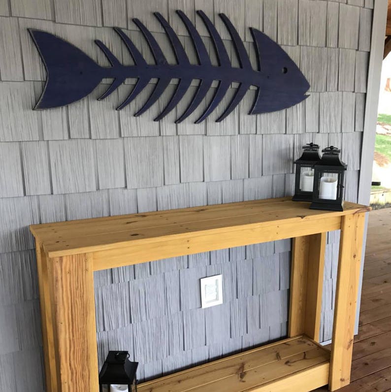 Haven America Fish Skeleton is shown outdoors in a boat house in our Atlantic Navy Blue color. Classic Nautical look.