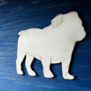 May include: White wooden cutout of a bulldog silhouette against a blue background.
