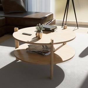 Puede incluir: Salón moderno con un sofá seccional de cuero marrón, un sillón negro y una mesa de centro de madera clara. La mesa de centro tiene dos niveles y contiene revistas y una pequeña planta. También hay una lámpara de pie con pantalla blanca.