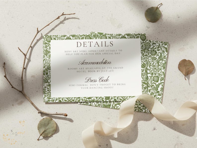 May include: A wedding details card with a green floral border and text that reads "DETAILS", "Accommodation", and "Dress Code". The card is accompanied by a ribbon, leaves, and a twig.