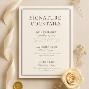 May include: A cream-colored cocktail menu with the words "Signature Cocktails" at the top. The menu features three cocktail recipes: Rosy Romance, Lavender Lush, and Citrus Kiss. A cream-colored ribbon, a gold wax seal, and a white rose are also present.