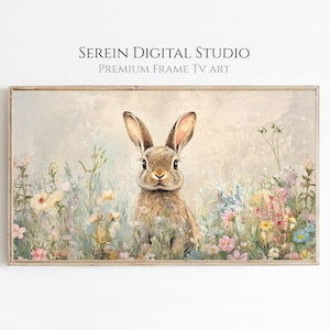 Puede incluir: Una impresión de arte digital enmarcada que presenta un conejo marrón en un campo de flores silvestres coloridas. La obra de arte tiene una paleta de colores pastel suaves con el texto "SEREIN DIGITAL STUDIO PREMIUM FRAME TV ART" en la parte superior.