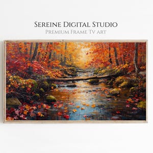 May include: A framed digital art print of an autumn landscape. The artwork depicts a stream flowing through a forest with vibrant red, orange, and yellow foliage. The text "SEREINE DIGITAL STUDIO PREMIUM FRAME TV ART" is at the top.