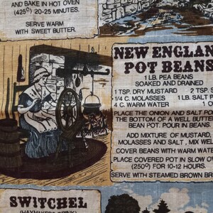 May include: A vintage kitchen towel featuring a recipe for New England Pot Beans. The recipe lists ingredients such as pea beans, dry mustard, molasses, salt pork, and onion. The towel also includes a drawing of a woman spinning yarn in a rustic setting.