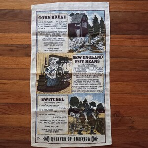 May include: A vintage-style tea towel with a beige background and brown text. The towel features three recipes: Cornbread, New England Pot Beans, and Switchel. Each recipe is accompanied by a small illustration.
