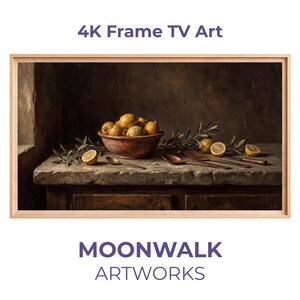 Könnte beinhalten: Ein gerahmtes digitales Kunstwerk mit einem Stillleben mit Zitronen in einer Schüssel, Olivenzweigen und Besteck auf einer Steinoberfläche. Das Kunstwerk ist vor einem dunklen Hintergrund platziert und in hellem Holz gerahmt. Text lautet "4K Frame TV Art" und "MOONWALK ARTWORKS."