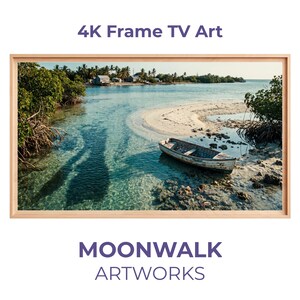 Peut inclure: Une impression encadrée d'une scène côtière avec un petit bateau sur le rivage. L'eau est claire et turquoise, et le ciel est bleu. Le cadre est brun clair. Le texte en haut indique "4K Frame TV Art" et en bas "MOONWALK ARTWORKS".