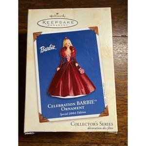 May include: A Hallmark Keepsake Ornament box featuring a Barbie doll in a red gown. The box has the text "CELEBRATION BARBIE ORNAMENT Special 2002 Edition" and "COLLECTOR'S SERIES". The ornament is a collector's item.