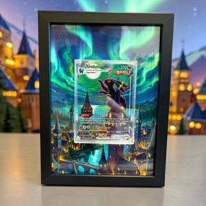 Può includere: Una carta Pokémon incorniciata con Umbreon V, ambientata in un paesaggio fantastico con cielo notturno e aurora boreale. La cornice nera circonda la carta e l'opera d'arte dettagliata.