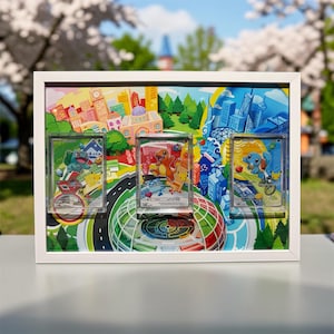 May include: A white framed display featuring three Pokemon trading cards. The background is a colorful cityscape with a road and a large, multi-colored sphere. The cards are in clear holders, showcasing the Pokemon characters.