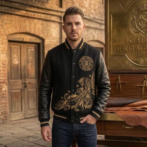 Peut inclure: Une veste style universitaire noire avec des manches en cuir noir et des broderies dorées représentant un tigre et des motifs floraux. La veste possède une fermeture à boutons-pression, des poignets côtelés rayés d'or et un emblème circulaire.