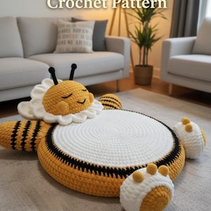 May include: A handmade crochet honeybee-shaped floor cushion with a white center, yellow and black striped body, and two white and yellow paw-shaped cushions. The text "Sleeping Honeybee Crochet Pattern" and "Instant PDF Download" are visible.