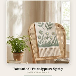 May include: A rectangular crochet wall hanging featuring a botanical pattern with sage green leaves and flowers on an off-white background, finished with a fringe at the bottom. The text reads Botanical Eucalyptus Sprig Mosaic Crochet Pattern.