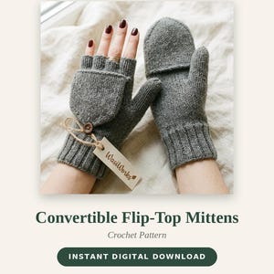May include: A pair of grey knit convertible flip-top mittens with a ribbed cuff. One mitten features a button-secured flap that can be folded back to expose the fingers. A small beige tag with the text WasiWorks is attached by twine.