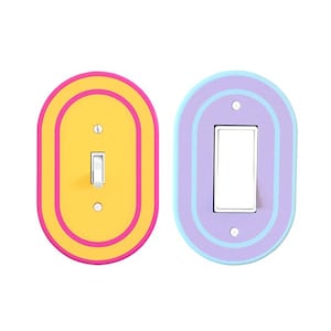 May include: Two colorful light switch covers. One is yellow with pink and orange accents, the other is purple with blue and lavender accents. Both have a rounded rectangular shape with a switch in the center.