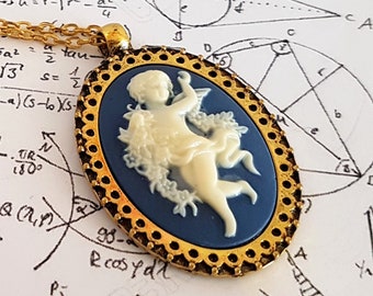 May include: A gold chain necklace with a blue and white cameo pendant featuring a cherub. The cameo is set in a gold oval frame with a decorative border. The necklace is lying on a sheet of paper with mathematical equations written on it.
