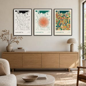 May include: Three framed wall art prints featuring maps of Jakarta, Indonesia. The left print is black and white, the center print features a soft orange circular overlay, and the right print displays a vibrant, multi-colored abstract map design.
