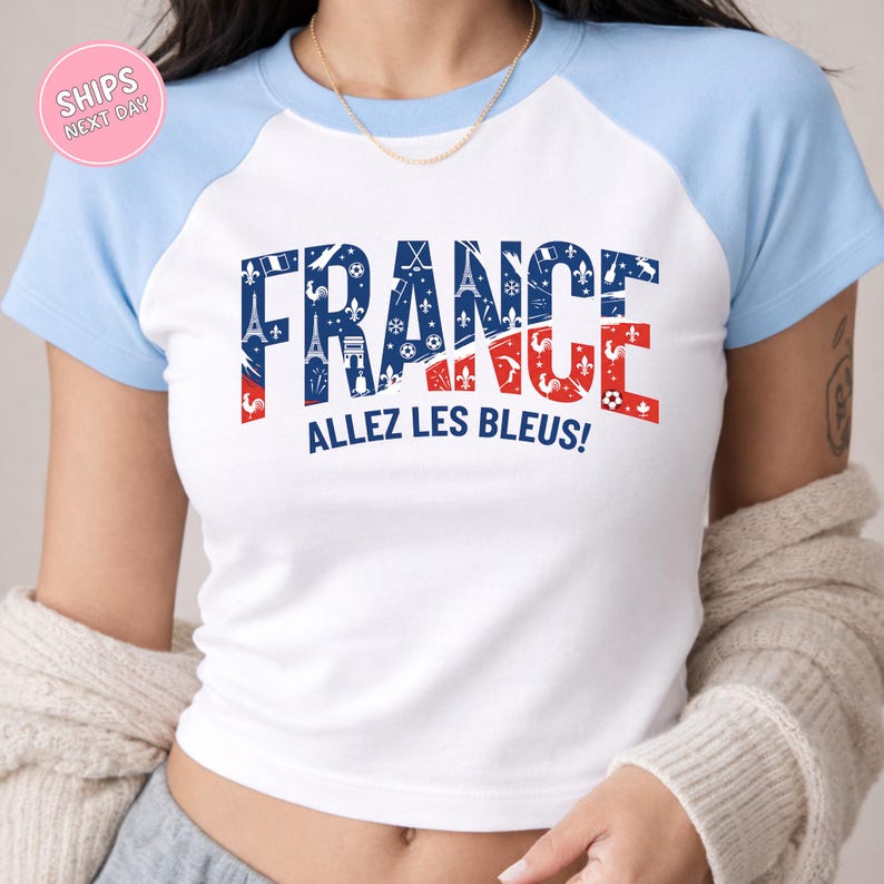 A woman wearing a white and blue t-shirt with the text "FRANCE" and "ALLEZ LES BLEUZ!" printed on it.