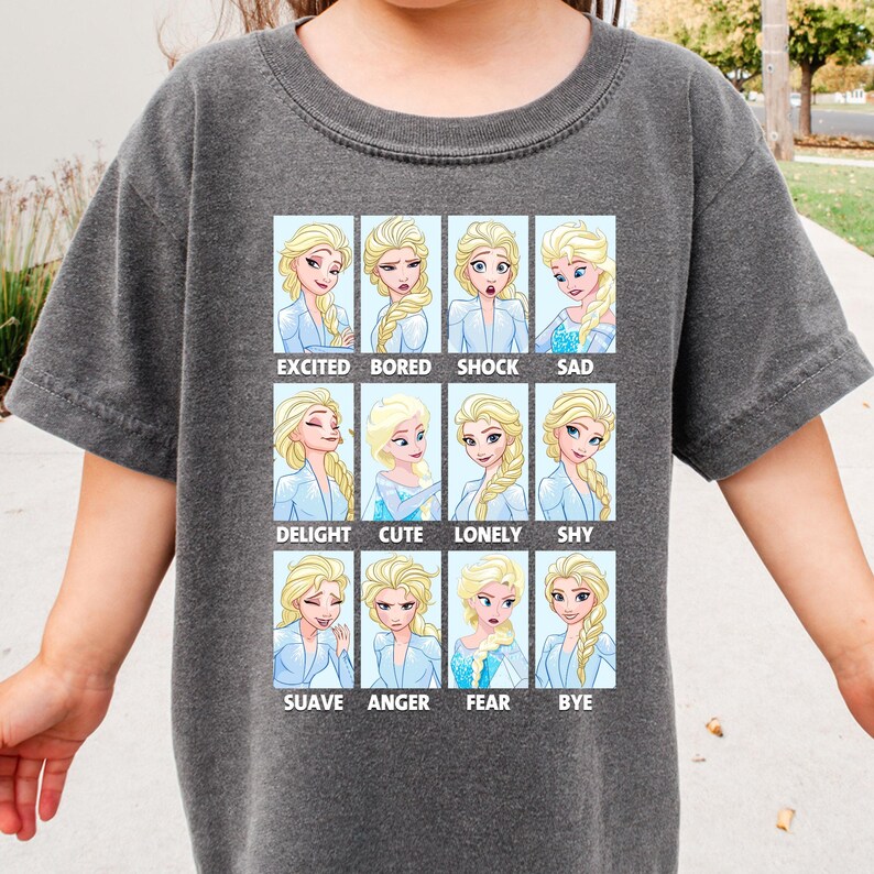 A gray t-shirt with a collage of twelve cartoon images of a blonde woman, each depicting a different emotion or facial expression.