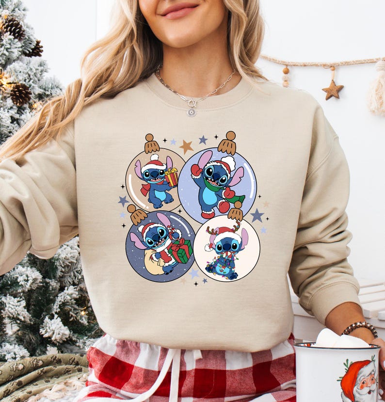 A woman wearing a beige sweater with a Christmas-themed graphic design featuring four cartoon characters from the Disney movie Lilo & Stitch.