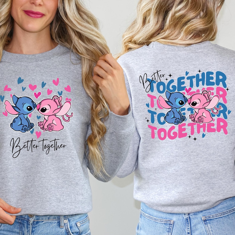 two women wearing gray sweatshirts with a cartoon character design and text on the back.
