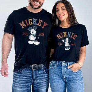 a man and a woman wearing mickey mouse shirts