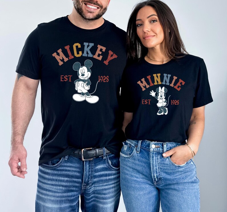 a man and a woman wearing mickey mouse shirts