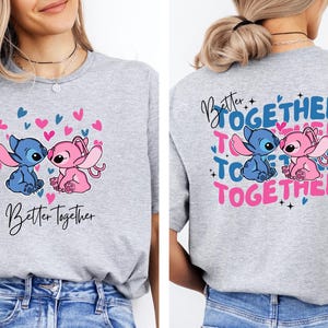 a woman wearing a gray t-shirt with a graphic design of two cartoon characters, a blue character and a pink character, along with the text "Better together" and "Together".