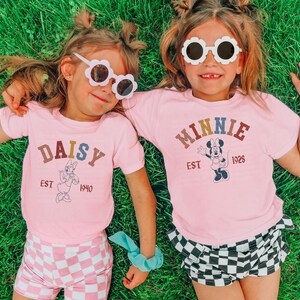 two little girls laying in the grass wearing matching shirts