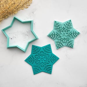 以下が含まれることがあります： 3つのターコイズ色の星型クッキーカッターとスタンプのセット。1つはシンプルなアウトラインで、他の2つは複雑な雪の結晶のデザインが特徴です。ホリデーベーキングや冬をテーマにしたお菓子に最適です。