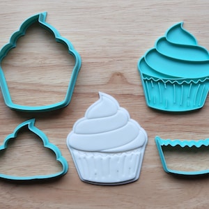 May include: A selection of cupcake-shaped cookie cutters in teal and white. The cutters feature detailed designs of frosting swirls and cupcake cases. Perfect for baking and crafting, these cutters are ideal for creating treats.
