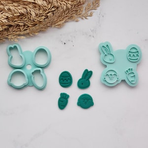 May include: A collection of turquoise Easter-themed cookie cutters. The set includes shapes of a bunny, egg, carrot, and a chick. The cutters are made of plastic and are designed for baking. The shapes are in a variety of sizes.