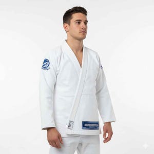 May include: White martial arts uniform with blue logo patches. The uniform includes a jacket with a V-neck and a wrap-around closure, and matching trousers. The jacket features a blue patch on the left sleeve and a rectangular patch near the bottom.