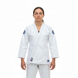 May include: White martial arts uniform with blue detailing. The jacket has a wrap closure, and the trousers are white. Blue patches are on the shoulders. This uniform is designed for martial arts training and competition.