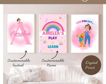 May include: Three framed digital prints with pink and white backgrounds. One features a pink letter A with the name "Amelia". Another has a rainbow and the text "Amelia's Play & Learn". The third print says "Can You Say..." with a cartoon character.