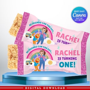 May include: Two rectangular rice cereal treats in pink wrappers with glittery edges. The wrappers feature a cartoon girl, an orange monster, a rainbow, a yellow bus, and the text: HI FRIENDS! CAN YOU SAY... RACHEL IS TURNING ONE!