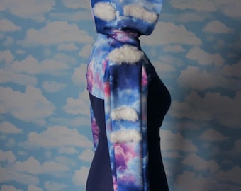 Bolero de nubes con capucha extragrande y detalle de nubes esponjosas en 3D. Nubes de arcoíris pastel o azul más oscuro.