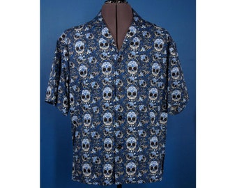 May include: A blue short-sleeved button-down shirt with a white and blue skull pattern.